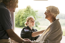 Paramedic Taking Care Of Senior Patient Sitting In Ambulance