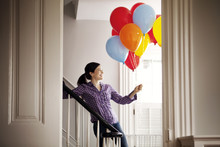 Smiling Woman With Balloons On Stairs