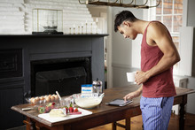 Young Man Cooking And Using Digital Tablet