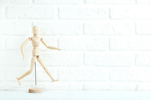 Wooden Figure On The Brick Wall Background