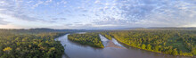 Aerial Panorama Of The Rio Napo At Dawn In The Ecuadorian Amazon With The First Rays Of The Sun Illuminating The Forest Canopy.