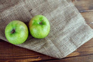 Two juicy green apples on the table. The concept of healthy eating and vegetarianism.