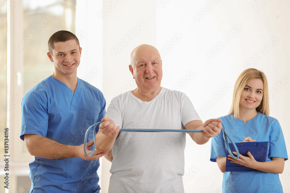 Physiotherapist working with elderly patient in clinic