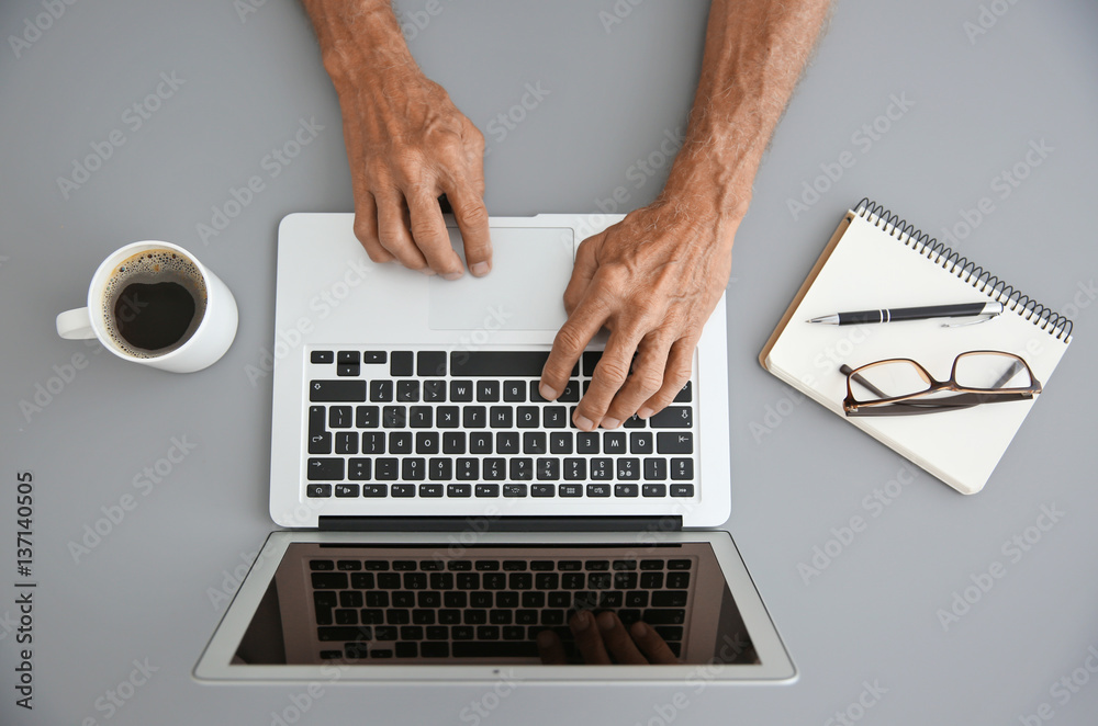 Male hands typing on laptop, top view