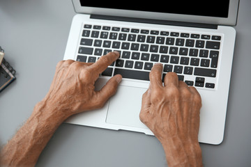 Canvas Print - Hands of senior man typing on laptop