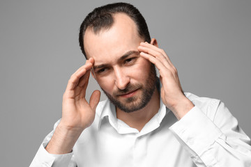 Wall Mural - Handsome man suffering from headache, on color background