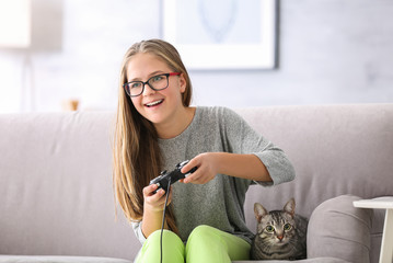 Wall Mural - Pretty teenager playing videogame at home