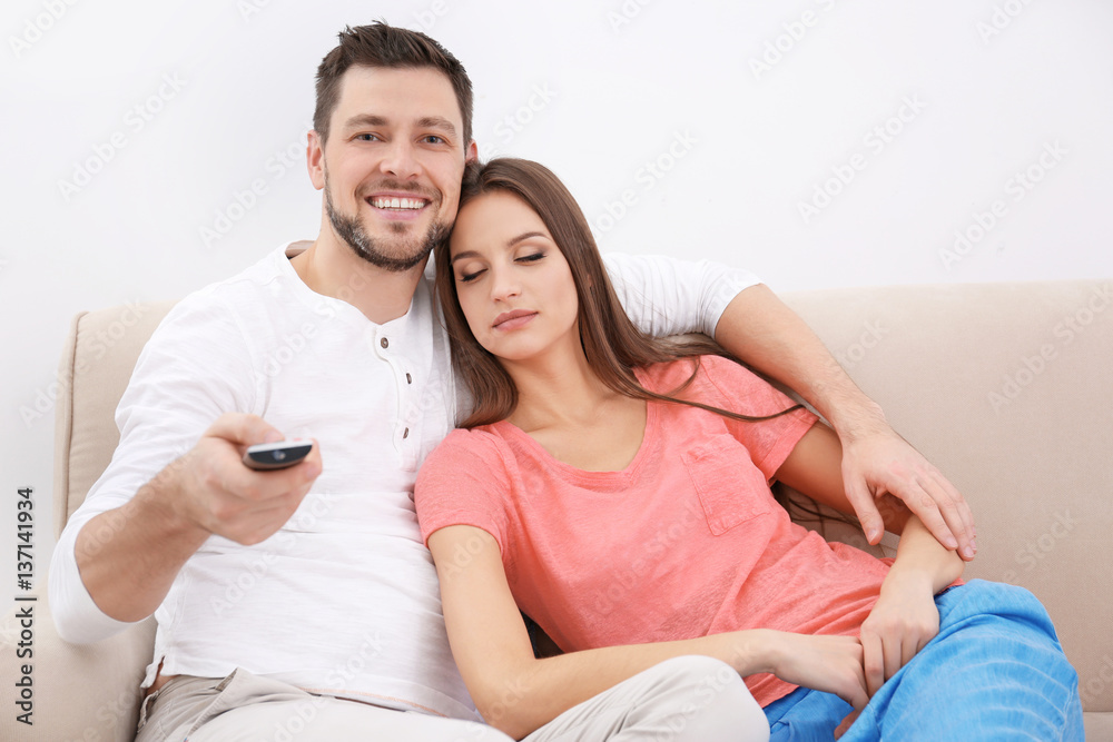 Young couple watching TV at home