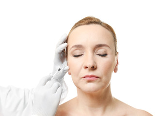 Wall Mural - Plastic surgery concept. Mature woman receiving injection on white background