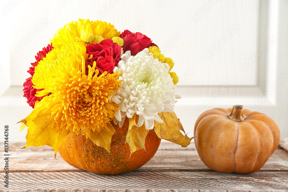Pumpkins and flowers on white blurred background