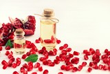 Fototapeta Tulipany - Pomegranate oil. Punica granatum ruby red fruit seeds, cosmetic vials. Facial nourishing oily extract. 