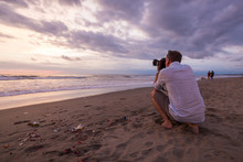 Photographer On The Beach At Sunset
