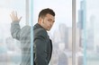 © nyul - Businessman in front of window looking back