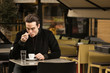 © HD92 - one young man sitting cafe tables coffee cup licking spoon
