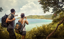 Travellers With Backpacks Watching Through Binoculars Enjoying Views Coast