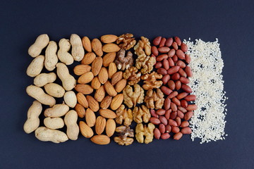 Assorted mixed nuts, peanuts, almonds, walnuts and sesame seeds.  Black background
