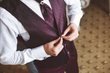 Poster - The groom buttons pink suit at the hotel.