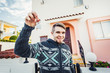 © satura_ - Happy funny man holds house keys on house shaped keychain in front of a new home