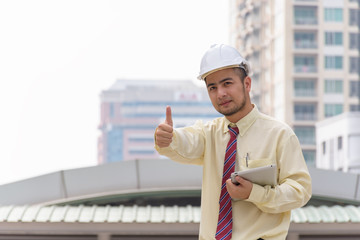 Business man thumbs thumb A confident stance, with the backdrop of the buildings in the city.