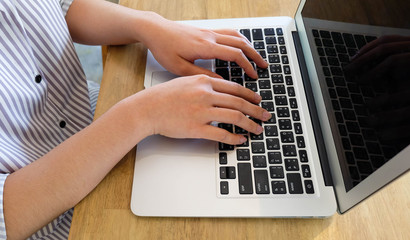 Woman office worker is typing keyboard of laptop, business or learning concept
