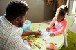 © Connect Images - Father and daughter enjoying colouring in activity