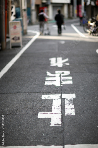 Plakat Asfaltowe wąskie uliczki w Tokio ze znakami drogowymi