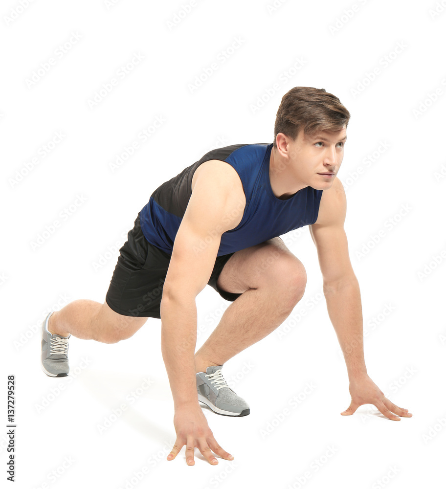 Young handsome sportsman doing exercises on white background