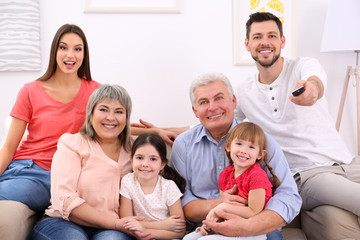 Wall Mural - Happy family watching TV on sofa at home