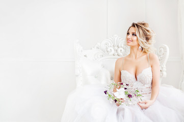 young bride is sitting in white armchair