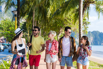 Wall Mural - young people group tropical beach palm trees friends walking speaking holiday sea summer vacation oc