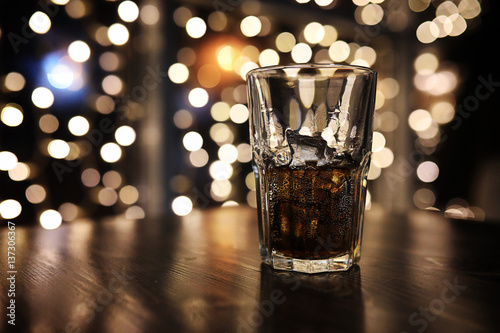 Fotomural Vaso de alcohol con hielo sobre fondo blured con círculo bokeh