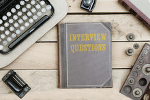Interview Questions On Old Book Cover At Office Desk With Vintage Items