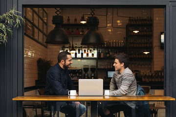 Friends using mobile and laptop.