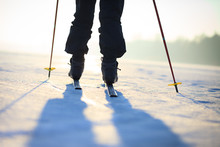 Active senior man cross-country skiing on huge snow meadow during lovely winter sunset