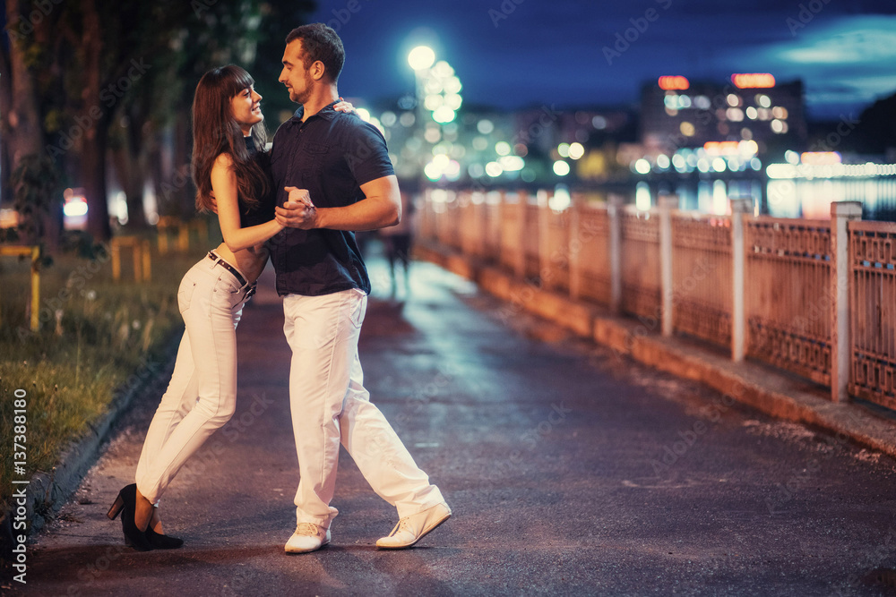 young couple dancing tango on the embankment - obrazy, fototapety, plakaty 