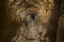 Inside Abandoned Gold Mine Tunnel Or Shaft In The Nevada Desert.  There Are Ore Cart Tracks On The Floor.  Shallow Depth Of Field With Focus About Half Way Down The Shaft.