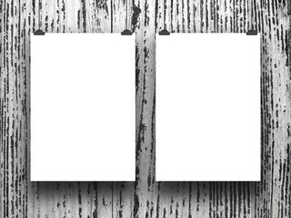 Two blank frames hanged by clips against gray wooden background