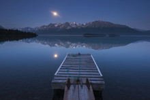 Boat Dock With A Full Moon Rising Over The Chigmit Mountains At Lake Clark In Lake Clark National Park And Preserve, Alaska.
