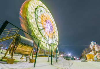  glowing attraction ferris wheel at night in winter