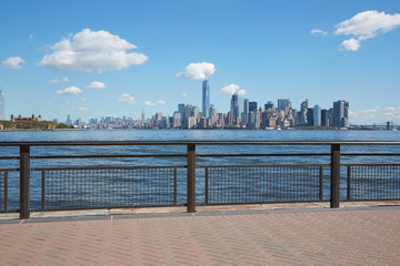 Wall Mural - New York city skyline view from empty dock with railing in a sunny day