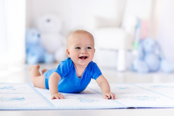 Wall Mural - Baby boy playing and learning to crawl