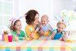 © famveldman - Mother with three children painting Easter eggs