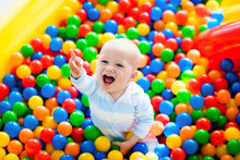 Child Playing In Ball Pit On Indoor Playground