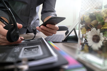 Poster - Man using VOIP headset with digital tablet computer docking keyboard,smart phone,concept communication, it support, call center and customer service help desk,vase flowers on wooden table