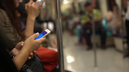 4K Asian People sit down in the train using Smartphone for play same game and check the social network to chat and contact people. Looking the phone device in a Subway of Taiwan-Dan