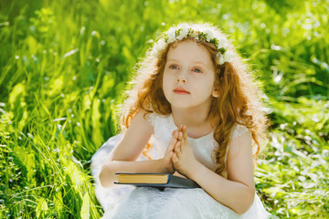 Wall Mural - Child with praying or dreaming  in the park outdoors.