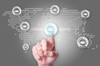 © Baramee - Network concept with close up of people hand touching icon on world map interface.