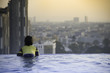 © Visanuyotin - little kid in swimming pool looking at beautiful cityscape