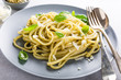 Homemade pasta, spaghetti, linguine with green pesto and basil. Italian healthy food concept.