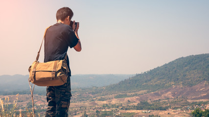 Closeup rear view of a photographer taking pictures on a mountain.